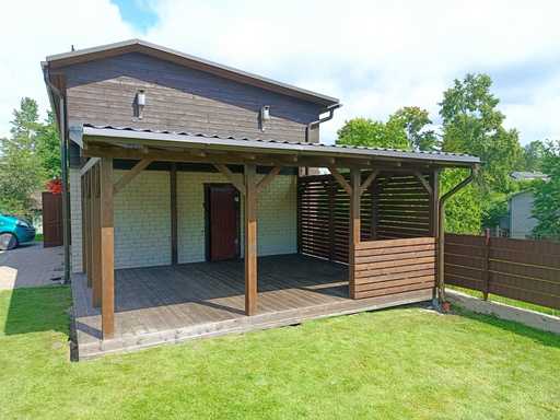 Mörkbrun träveranda fäst vid huset med täckt tak – 4,8×6 m