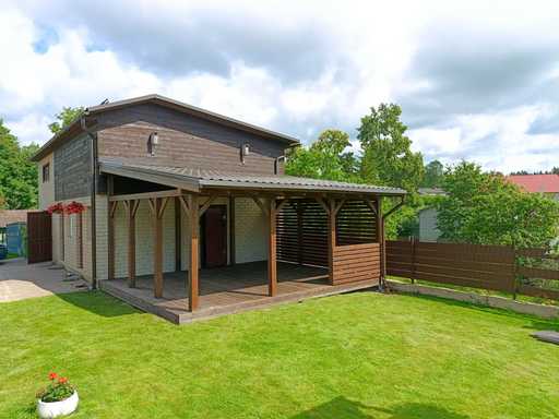 Mörkbrun träveranda fäst vid huset med täckt tak – 4,8×6 m